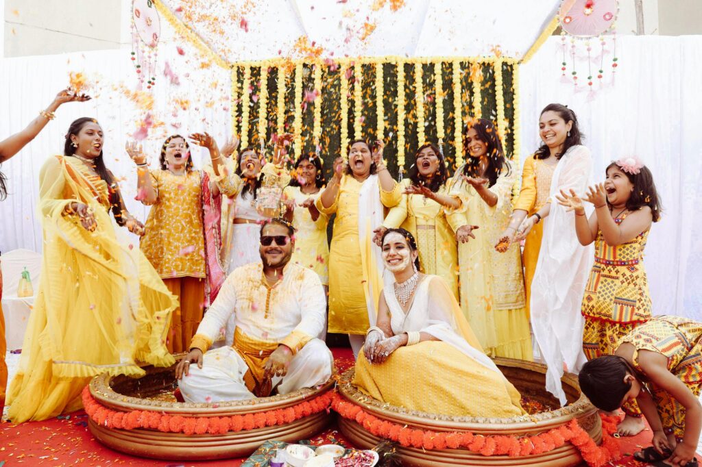 A joyful Indian Haldi ceremony with family and friends in colorful attire, capturing tradition and happiness.